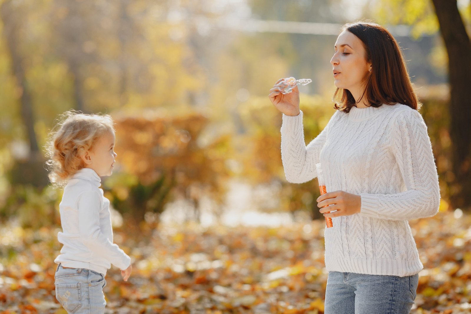 Young woman and kid blowing soap bubbles in park 4173142 scaled